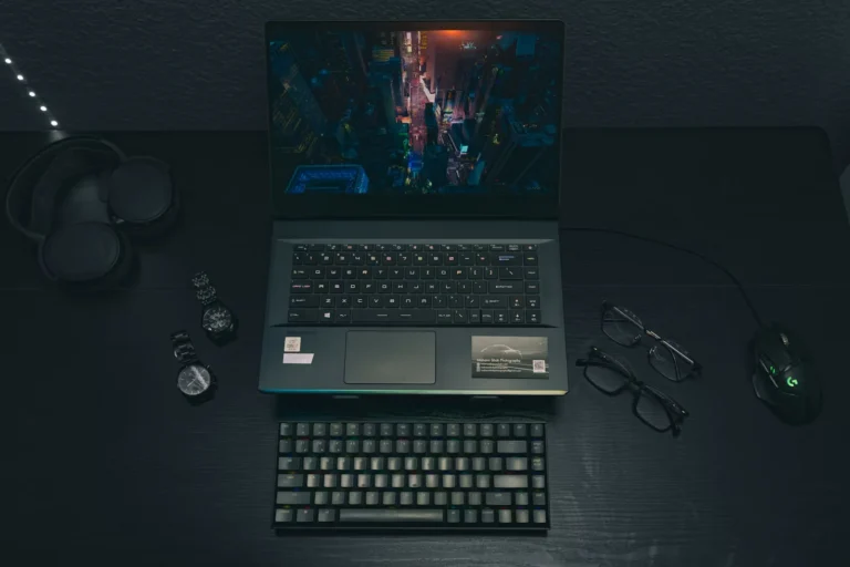 a laptop lying on a table with glasses